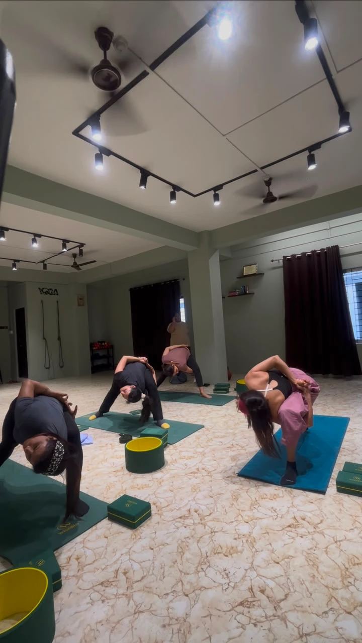 Small group practising standing bound forward bends at Paathway2Yoga studio in Guwahati